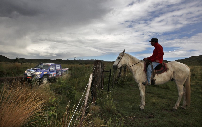 A farm worker watches the second stage of the third South American edition of the Dakar Rally 2011 from Cordoba to Tucuman