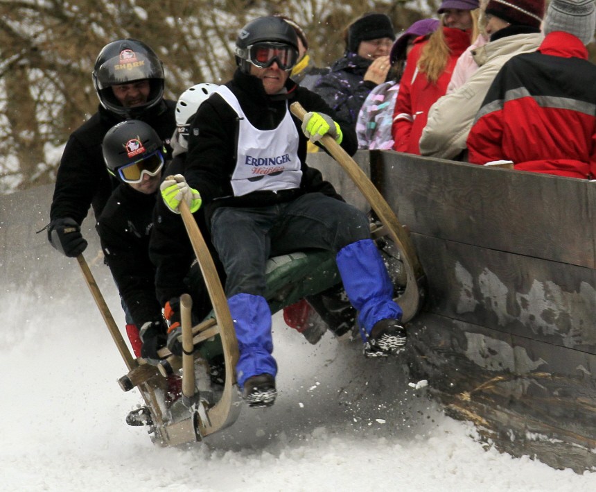 The four-men crew of a traditional Bavarian wooden sledge crashes into a barrier during the 42nd international Bavarian 'Hornschlitten' race in Garmisch-Partenkirchen