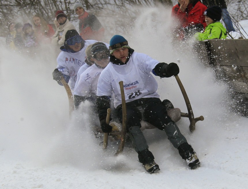 Snow sprays as the four-men crew of a traditional Bavarian wooden sledge speeds down during the 42nd international Bavarian 'Hornschlitten' race in Garmisch-Partenkirchen