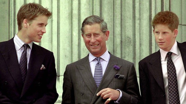 PRINCE CHARLES SMILES AS HE STANDS WITH HIS TWO SONS AT BUCKINGHAM PALACE