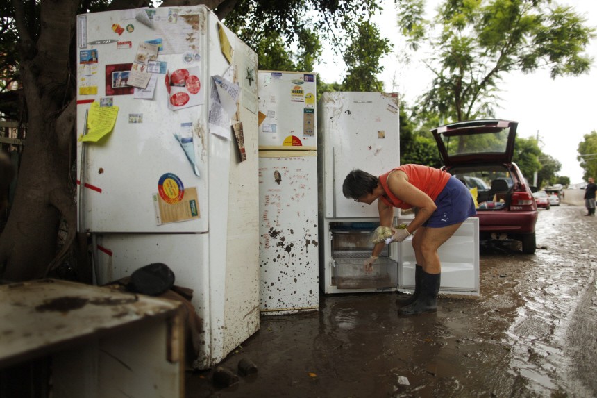 A woman removes produce from damaged refrigerators after flood waters receded in Brisbane