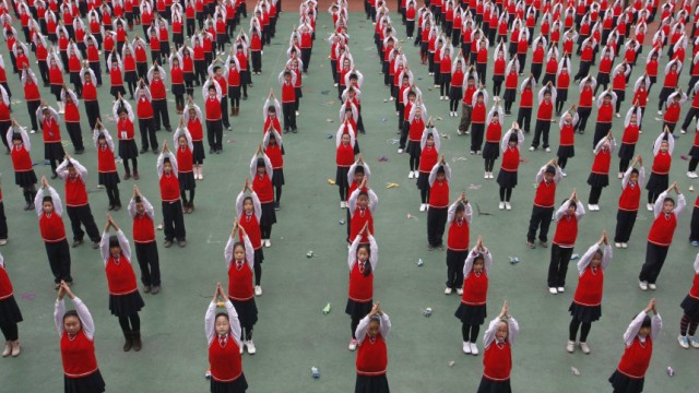 Pupils attend a Yoga exercise session during break time at a primary school in Suining
