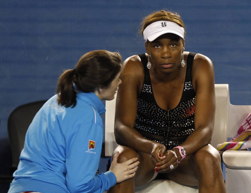 A trainer attends to Williams of the U.S. after Williams retired from her match against Petkovic of Germany at the Australian Open tennis tournament in Melbourne
