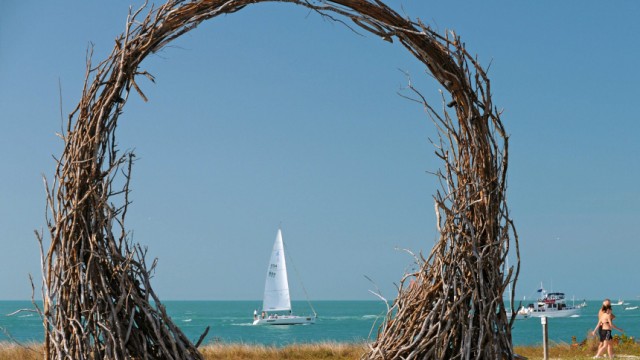A sailboat is framed by a wood sculpture in Florida