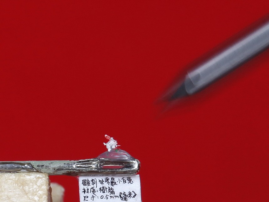A miniature resin figurine of a rabbit is displayed on a needle in Taipei