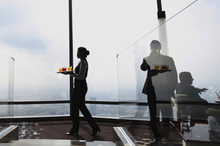 A waitress carries drinks during the opening of 'At.Mosphere' the world's highest restaurant in the Burj Khalifa in Dubai