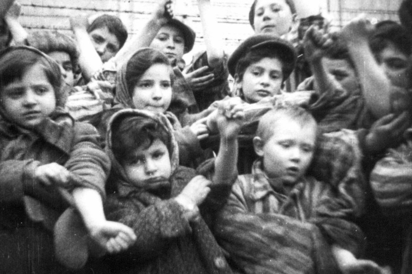 File photograph of  children, who survived Auschwitz II-Birkenau, show their tattooed identification numbers