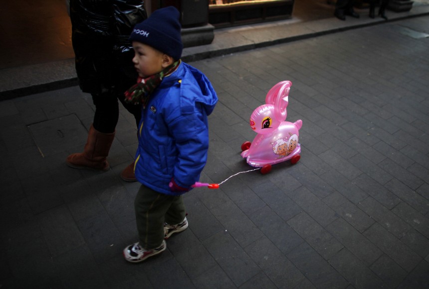 A boy with a toy rabbit walks at the Yuyuan Garden in downtown Shanghai