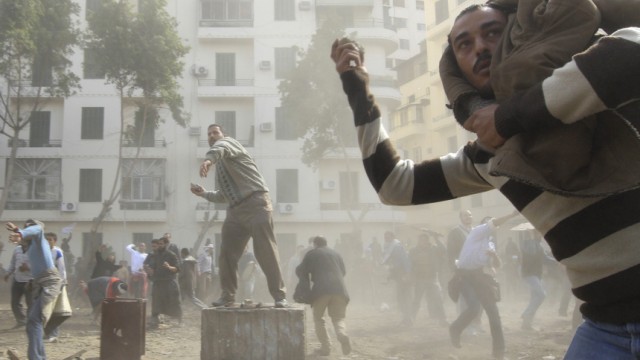 Opposition supporters throw stones at pro-Mubarak demonstrators in Tahrir Square in Cairo