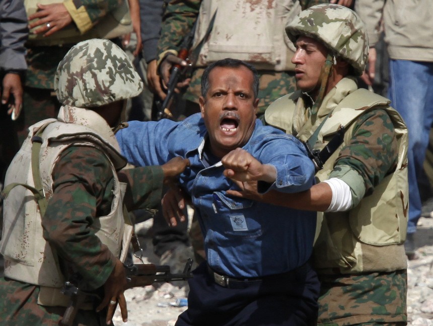 Egyptian soldiers restrain a supporter of Mubarak who tried to get to opposition lines near Tahrir Square in Cairo