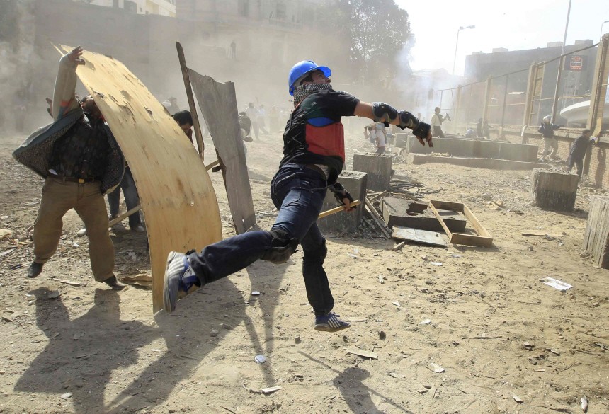 Opposition supporters throw stones at pro-Mubarak demonstrators in Tahrir Square in Cairo