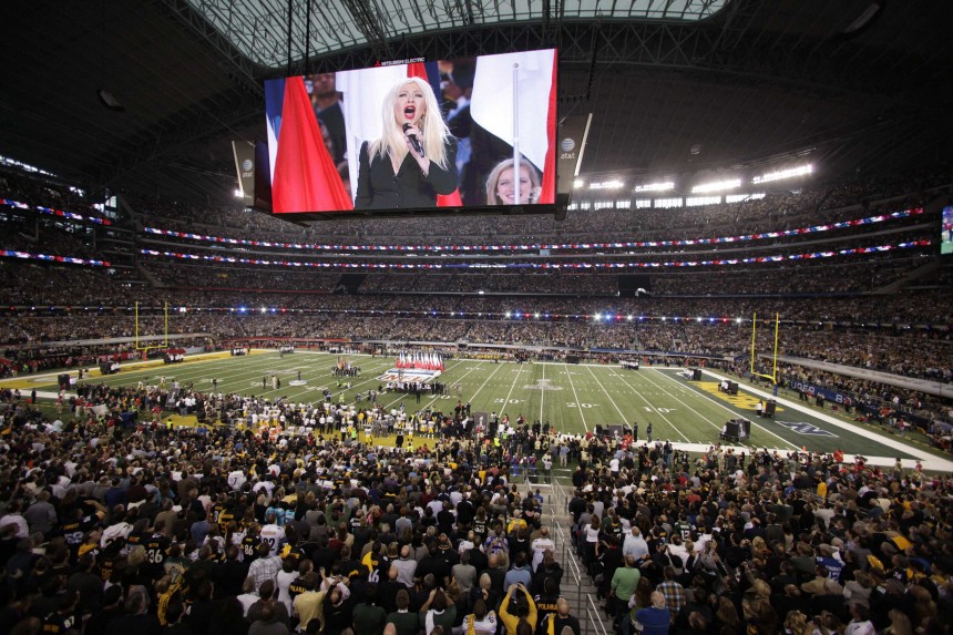 Christina Aguilera is shown on the giant screens above the field as she performs the National Anthem before the NFL's Super Bowl XLV football game in Arlington