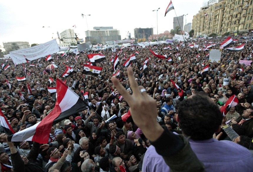 Anti-government protesters celebrate after a senior army general addressed the crowd inside Tahrir Square in Cairo