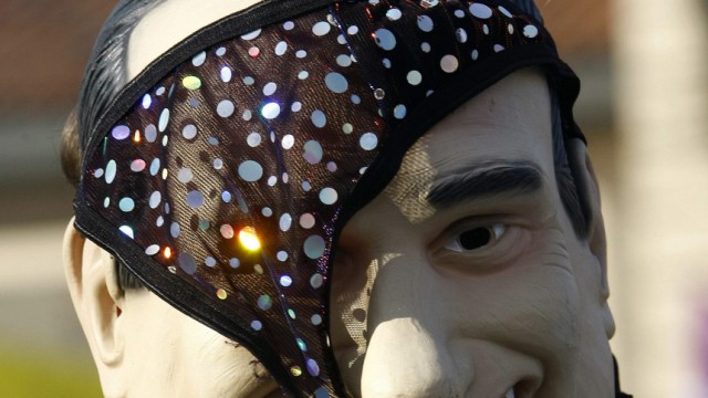 A protester wears a mask of Italian Prime Minister Silvio Berlusconi with a pair of knickers on it during a protest in Arcore
