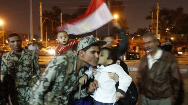 Ägypten - die Rolle des Militärs: Ein Soldat küsst einen kleinen Jungen auf dem Tahrir-Platz in Kairo: Die Taktik der Uniformierten hat den Rückzug des Präsidenten erst ermöglicht.