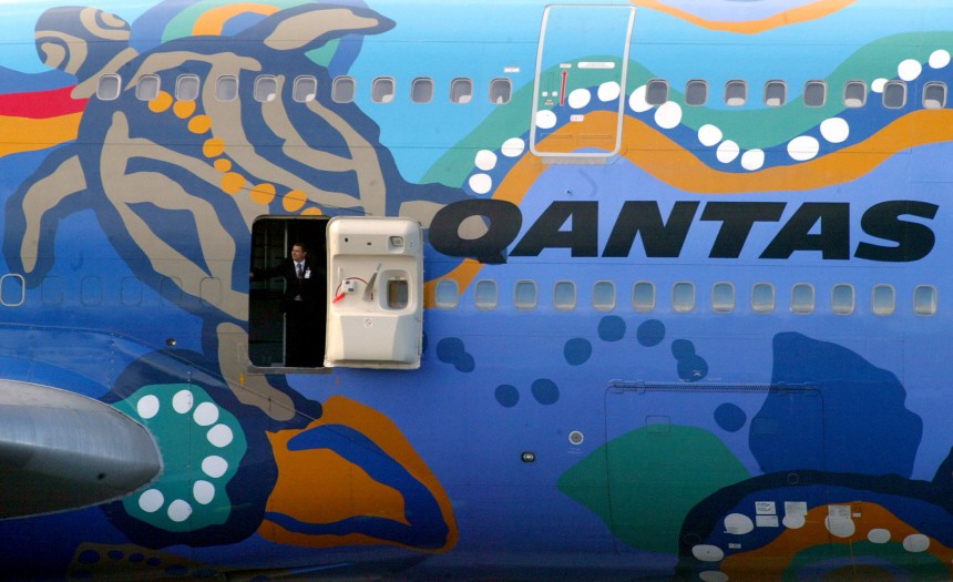 QANTAS STEWARD LOOKS OUT OF PLANE DOOR AT SYDNEY AIRPORT