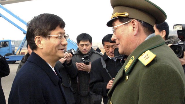 China's public security minister Meng Jianzhu is greeted by North Korean official upon his arrival at an airport in Pyongyang
