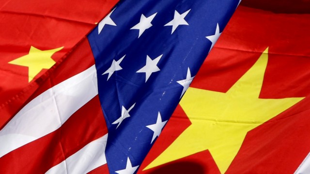 The national flags of the U.S. and China wave in front of an international hotel in Beijing