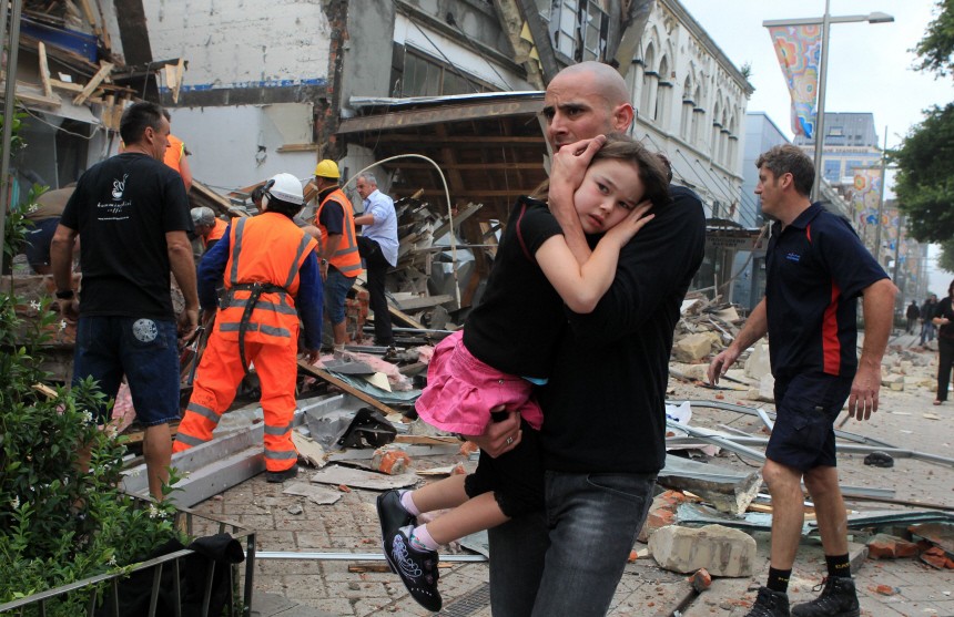 A man holds a child in his arms after an earthquake in Christchurch