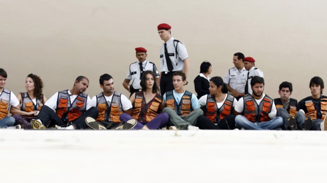 Security guards watch over Greenpeace activists arrested for raising inflatable model of wind turbine in Brasilia