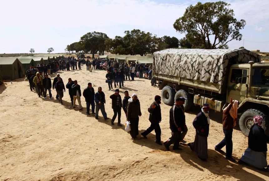 Egyptian refugees fleeing violence in Libya line up to be processed at a refugee camp after crossing into Tunisia near the border crossing of Ras Jdir