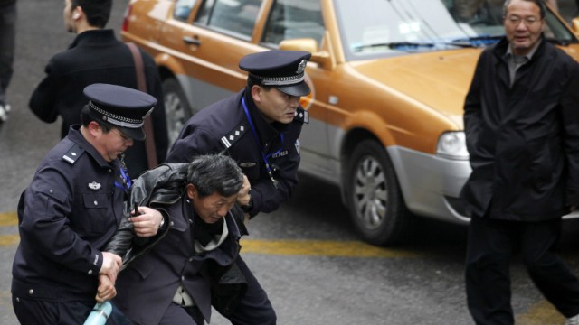 Police arrest a man in front of the Peace Cinema in downtown Shanghai, after calls for a 'Jasmine Revolution' protest, organised through the internet