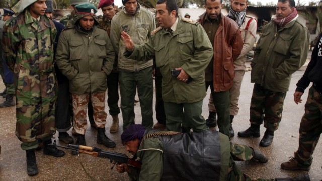 Rebel army officers teach the use of a AK-47 to civilians who have volunteered to join the rebel army in Benghazi