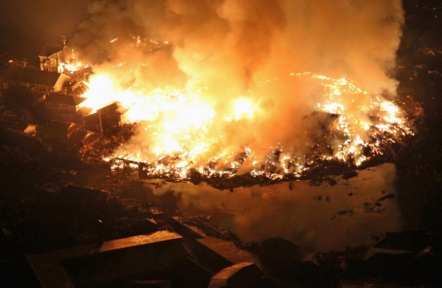 Houses burn at night following an earthquake in Natori City, Miyagi Prefecture, northeastern Japan