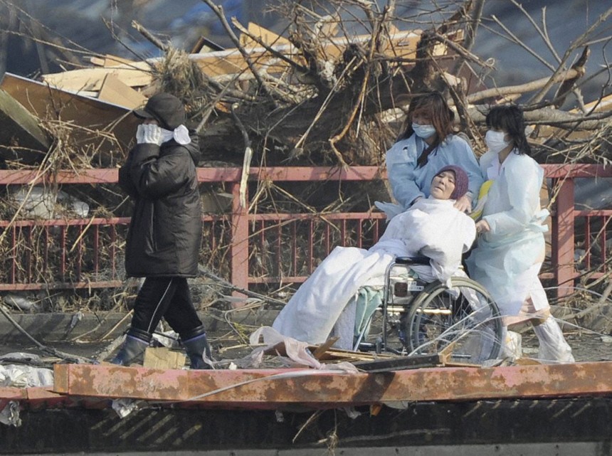 A patient is evacuated from a destroyed hospital after a magnitude 8.9 earthquake and tsunami hit Otsuchi Town