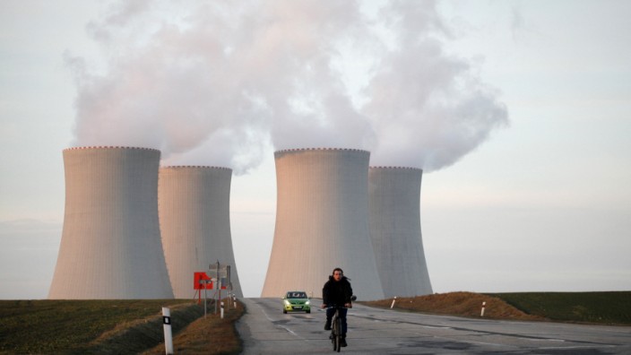 A man rides his bicycle away from the the cooling towers of the Temelin nuclear power plant near Tyn nad Vltavou