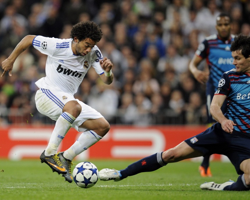 Real Madrid's Marcelo gets past Olympique Lyon's Lovren to score during their second leg round of 16 Champions League soccer match in Madrid