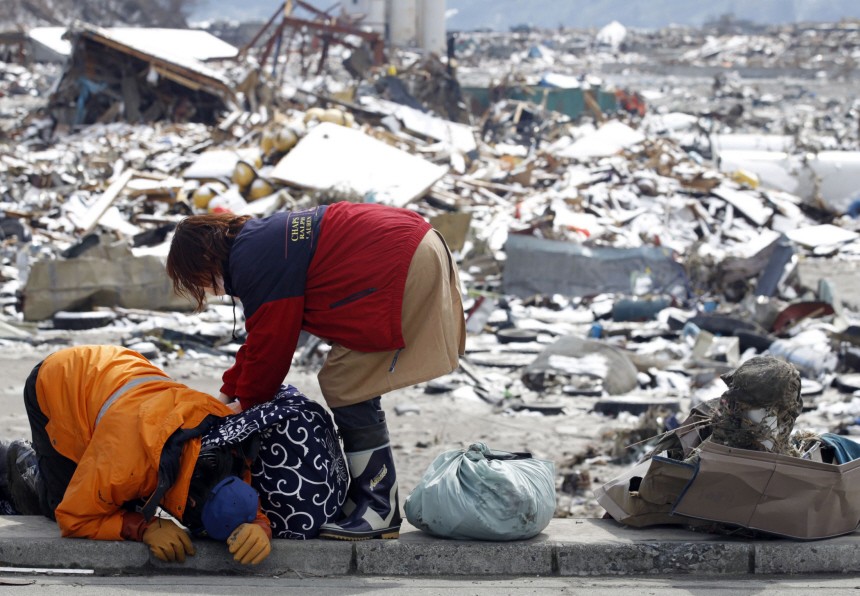 Survivors react after collecting their belongings at their destroyed house in a village hit by an earthquake and tsunami in Otsuchi