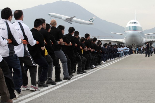 People pull a Cathay Pacific Boeing 747-400 weighing 210 tons during an attempt to break the world record in Hong Kong's Airport