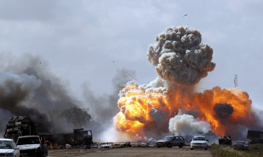Vehicles belonging to forces loyal to Libyan leader Muammar Gaddafi explode after an air strike by coalition forces, along a road between Benghazi and Ajdabiyah