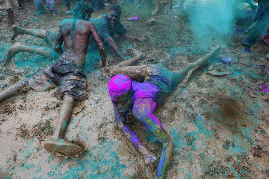 Men covered in coloured powder called abeer dance in mud during Phagwa celebrations at the Arranguez