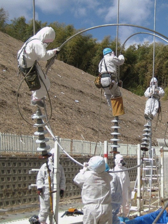 Handout photo from Tokyo Electric Power Co. shows worker attempting to repair power lines at the Fukushima Daiichi Nuclear Power Plant in Tomioka