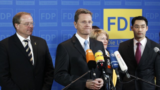Leader of FDP Westerwelle and party fellows Roesler and Niebel react after hearing first exit polls for Baden-Wuerttemberg and Rhineland-Palatinate state election at party headquarters in Berlin
