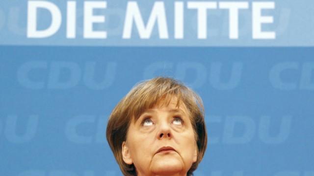 German Chancellor and leader of CDUMerkel looks up during news conference after party meeting in Berlin