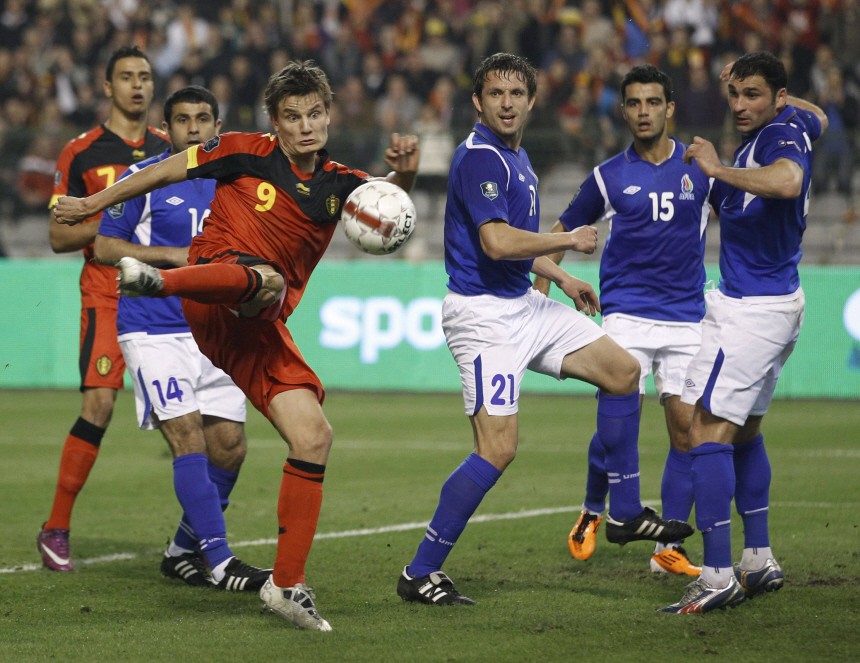 Belgium's Vossen kicks the ball past Azerbaijan's players during their Euro 2012 qualifying soccer match in Brussels
