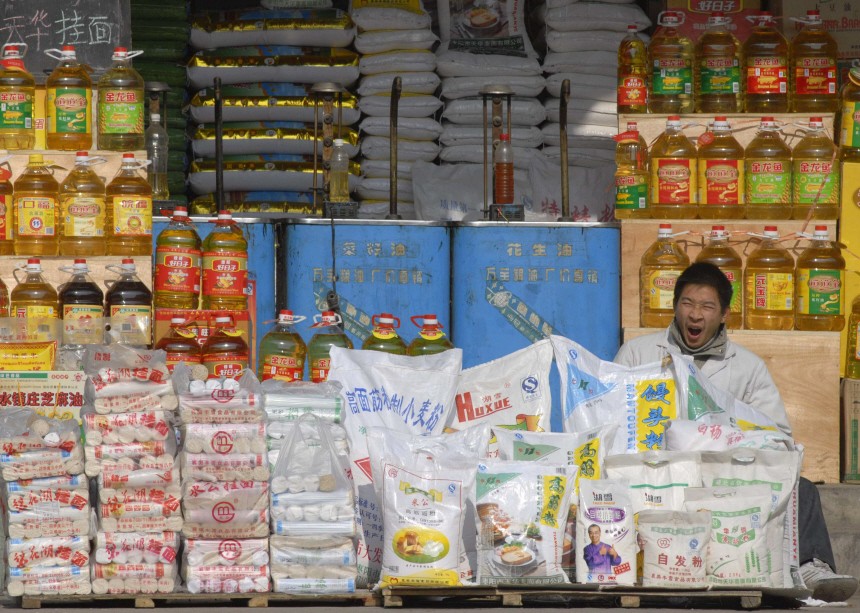 A vendor yawns as he waits for customers at a grain shop in Xiangfan