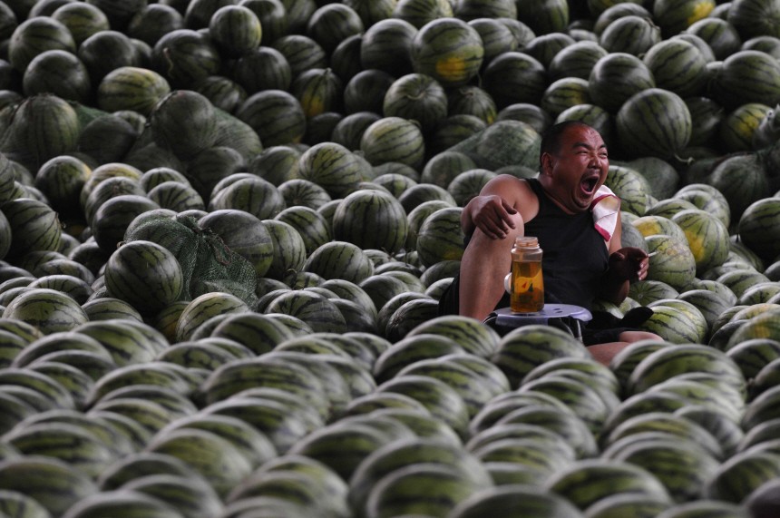A vendor yawns as he waits for customers at a watermelon stall in Changzhi,