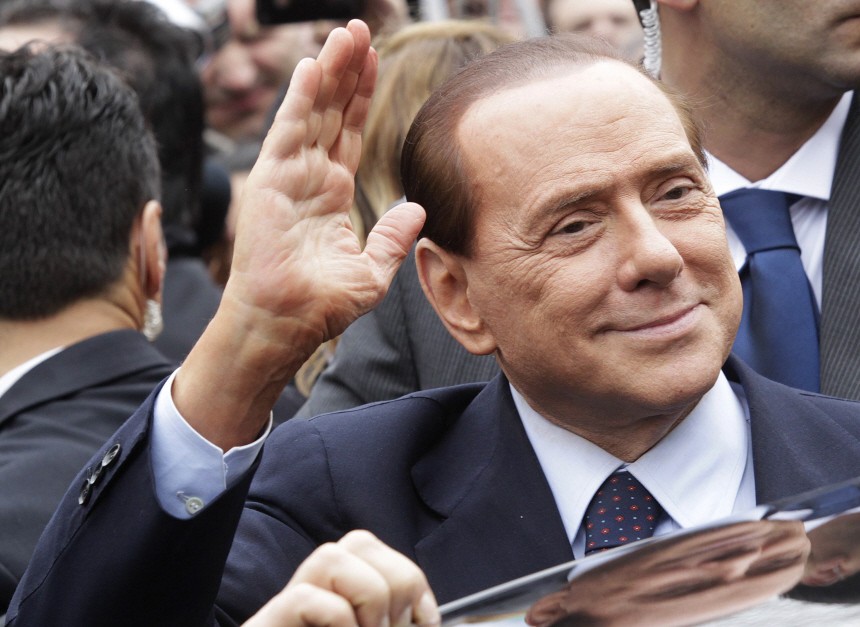 Italy's Prime Minister Silvio Berlusconi gestures as he leaves the Justice Palace in Milan