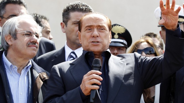 Italian PM Berlusconi speaks after arriving at at the southern Italian island of Lampedusa