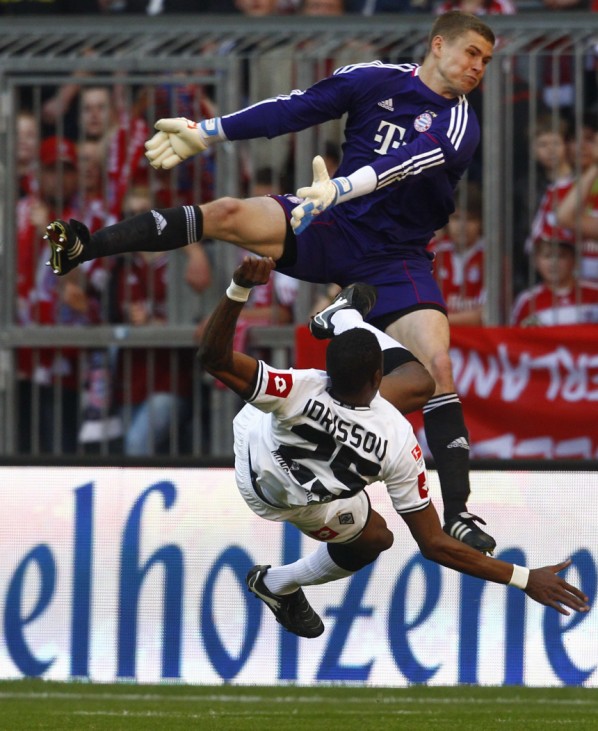 Kraft, goalkeeper of FC Bayern Munich makes a save against Mohamadou Idrissou of Borussia Moenchengladbach during their Bundesliga soccer match in Munich
