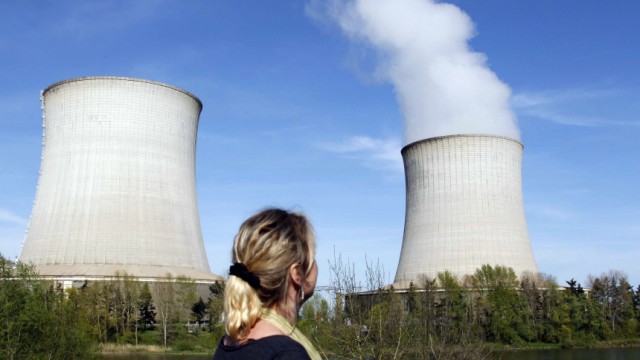A woman looks at cooling towers of France's Electricite de France nuclear power station in Saint Laurent, Central France