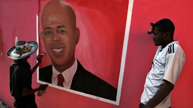 Haitian artist Hilaire Dieuseul Peentre puts the final touches to his painting of Haitian presidential candidate Michel Martelly in Port-au-Prince