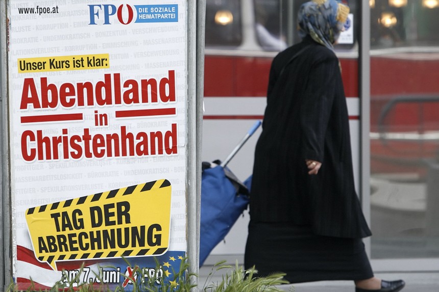 A woman passes an Austrian Freedom Party (FPOe) controversial European parliament election campaign poster in Vienna