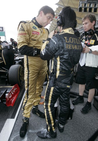 Renault's Petrov talks to crew members before the Malaysian F1 Grand Prix at Sepang circuit outside Kuala Lumpur