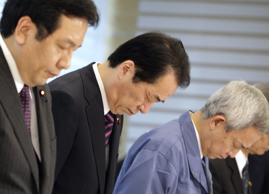 Japanese Prime Minister Kan observes a moment of silence prior to an emergency disaster measures meeting in Tokyo