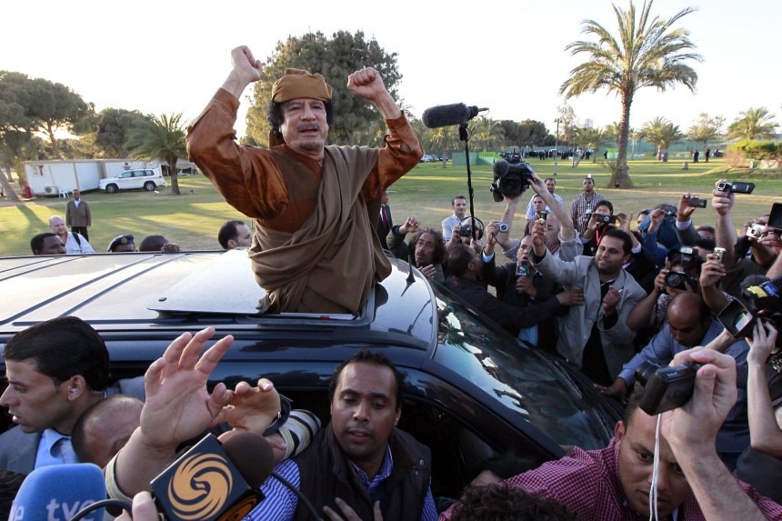 Libyan leader Muammar Gaddafi waves from a car in the compound of Bab Al Azizia in Tripoli